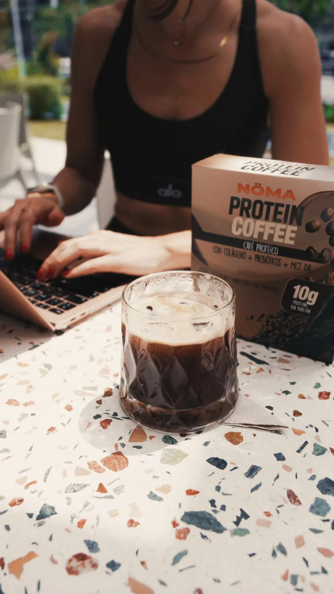 Café NÖMA frío junto a una laptop durante la jornada de trabajo